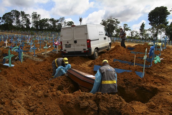 Cemetery workers bury 89-year-old Abilio Ribeiro, who died of the new coronavirus, at the Nossa Senhora Aparecida cemetery in Manaus, Amazonas state, Brazil, Wednesday, Jan. 6, 2021. (AP Photo/Edmar B ...