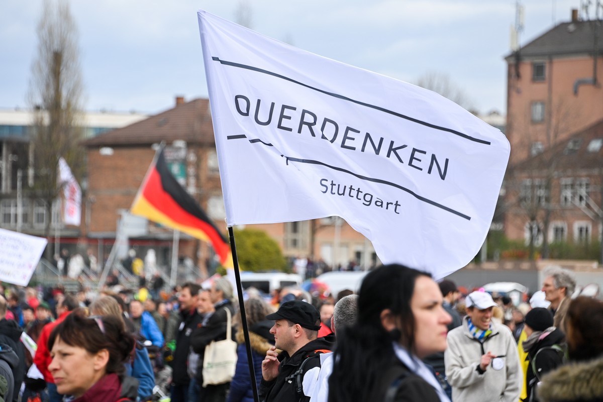 epa09113214 A protester holds a Querdenken flag during a demonstration held by the ?Querdenker' (lateral thinkers) movement against the German government's coronavirus restrictions in Stuttg ...
