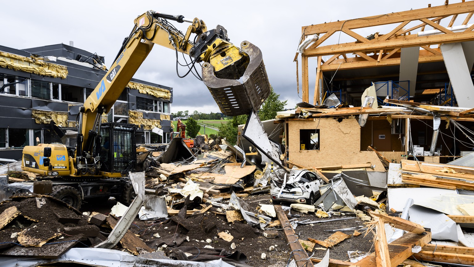 Des ouvriers enlevent les debris entre l&#039;entreprise Sellita Watch et l&#039;entreprise La Semeuse, un jour apres le passage de la forte tempete le mardi 25 juillet 2023 au Cret-du-Locle a cote de ...