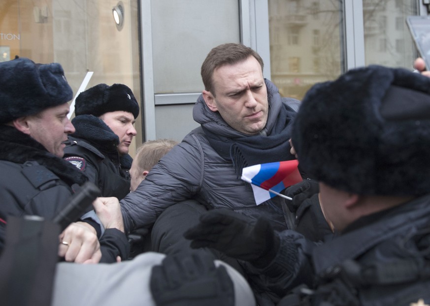 Russian opposition leader Alexei Navalny, centre, is detained by police officers in Moscow, Russia, Sunday, Jan. 28, 2018. Opposition politician Alexey Navalny calls for nationwide protests following  ...