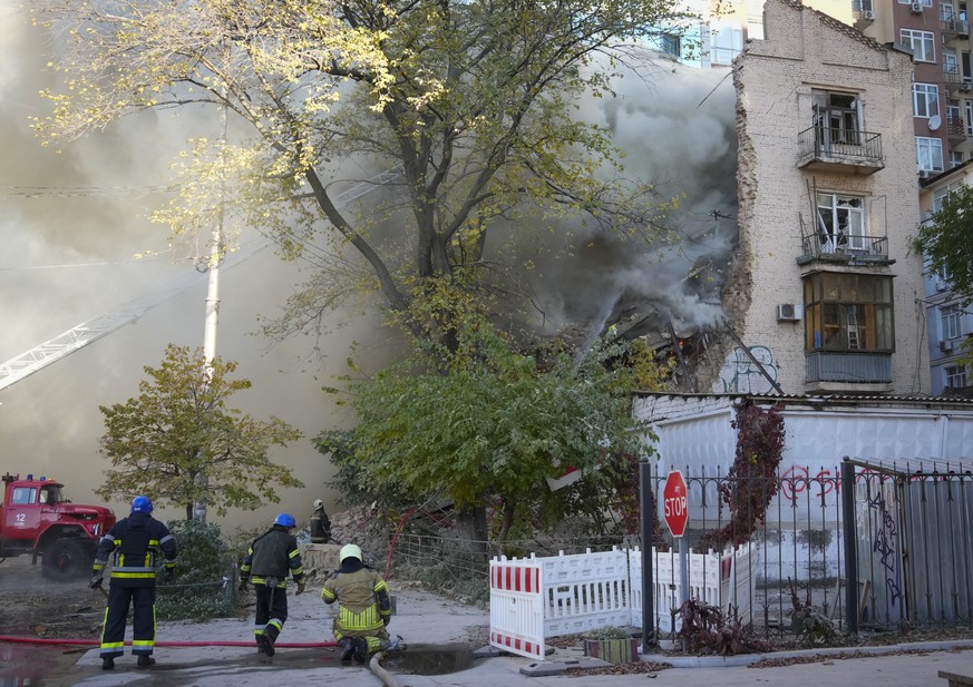 Firefighters work after a drone fired on buildings in Kyiv, Ukraine, Monday, Oct. 17, 2022. (AP Photo/Efrem Lukatsky)