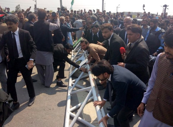 epa10529564 Supporters of former prime minister Imran Khan gather near a court where Khan is set to appear, Islamabad, Pakistan, 18 March 2023. Khan is set to make a court appearance for proceedings o ...