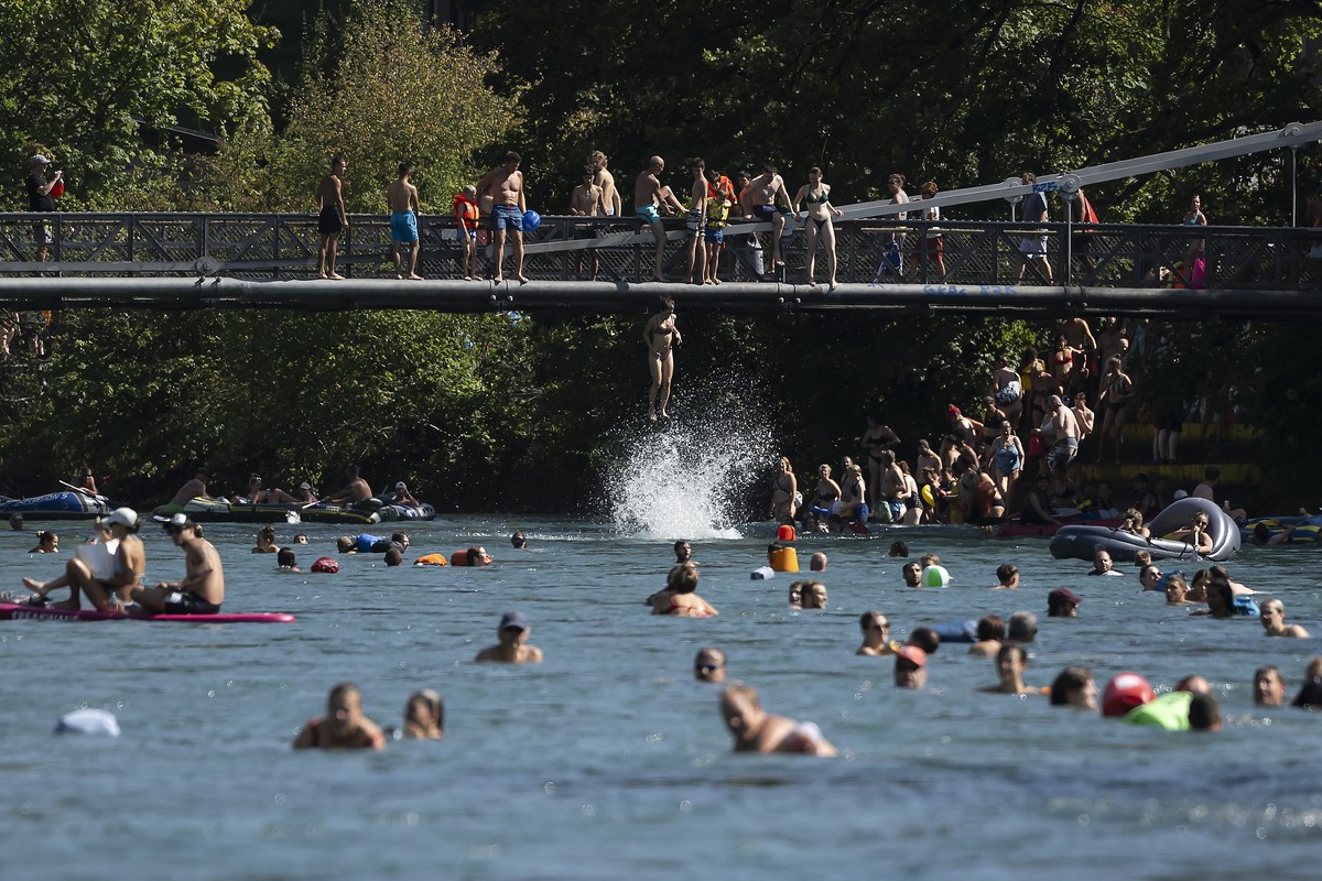 epa10810771 A woman jump from Schonausteg bridge in the Aare River during the sunny and warm weather in Bern, Switzerland, 20 August 2023. Many parts of Switzerland have been experiencing a period of  ...