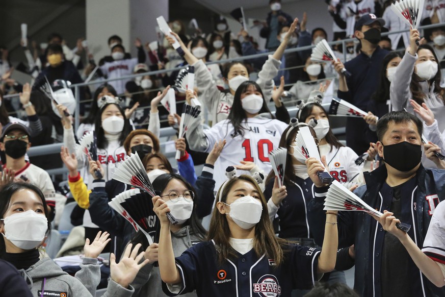 Fans wearing face masks as a precaution against the coronavirus cheer during the Game 4 of the Korean Series, the Korea Baseball Organization's championship round, between Doosan Bears and NC Dinos at ...