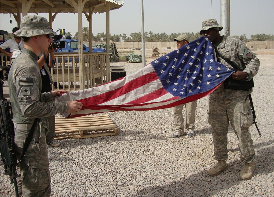 epa13267926 (FILE) - US soldiers fold their national flag while preparing to leave Scania military base in Hila south of Baghdad, Germany, 15 July 2010 (reissued on 28 September 2026). The internation ...
