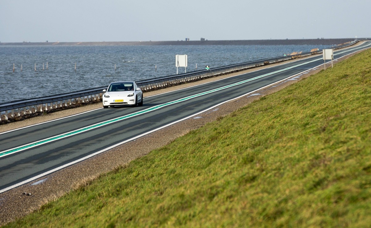 11. Januar 2023, Lelystad, Flevoland, Niederlande: Ein weisses Tesla-Fahrzeug auf dem Houtribdijk, einem 27 Kilometer langen Deich, der die Städte Lelystad und Enkhuizen in den Niederlanden verbindet.