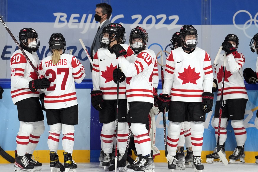 Canada players and coaches wear COVID masks as players warm up before a preliminary round women&#039;s hockey game against Russian Olympic Committee at the 2022 Winter Olympics, Monday, Feb. 7, 2022,  ...