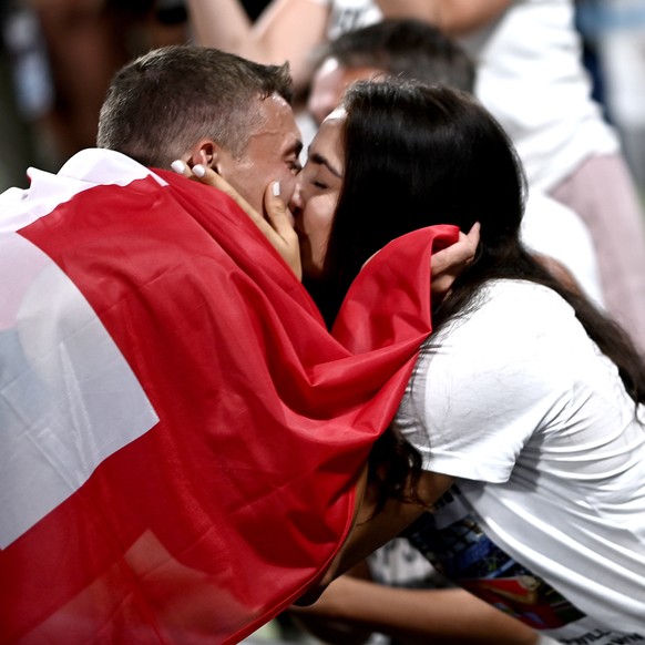 epa10124960 Simon Ehammer (L) of Switzerland gets a kiss after placing second in the Decathlon during the Athletics events at the European Championships Munich 2022, Munich, Germany, 16 August 2022. T ...