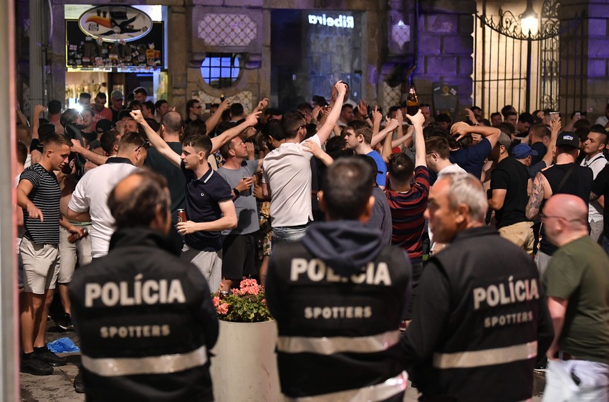 Police spotters watch as English supporters drink and sing on Friday, June 7, 2019 in the city center of Porto, Portugal, the day after England lost their UEFA Nations League semifinal soccer match ag ...