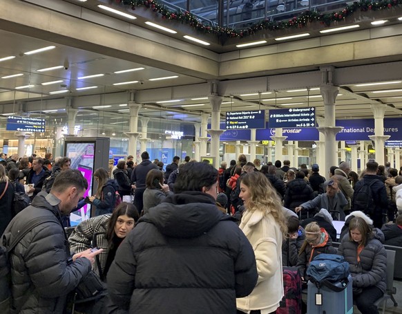 Passengers wait in the hall at the entrance to the Eurostar at St Pancras International station, central London, after high-speed services between London and Ebbsfleet were canceled due to flooding...