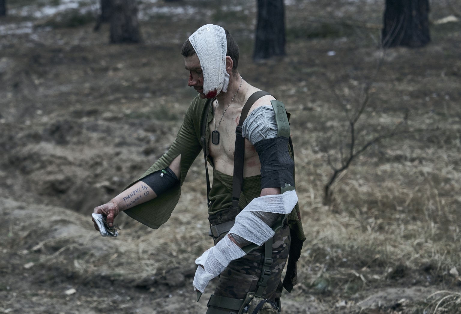 A soldier wounded in a battle with the Russian invaders approaches a medic car to get evacuated near Kremenna in the Luhansk region, Ukraine, Sunday, Jan. 15, 2023. Writing on his right hand lists the ...