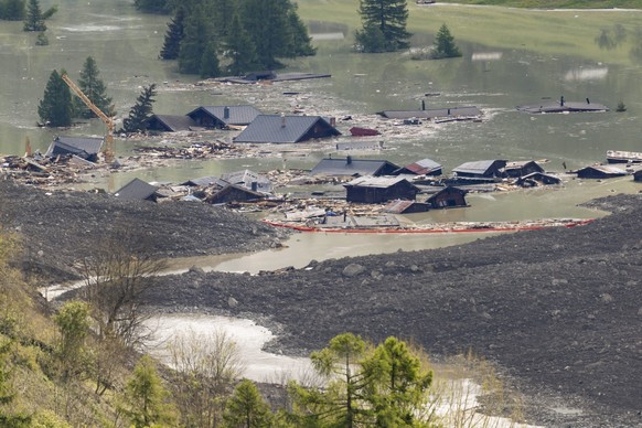 Check dams have been set up on the water from the Lonza river flows over the mud and stone, after the formation of a lake on the last houses of the village of Blatten, Sunday, June 1, 2025. A large pa ...