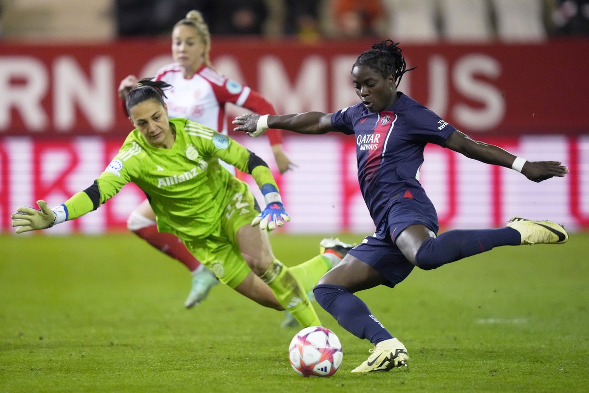 PSG's Tabitha Chawinga, right, scores her side's first goal past Bayern goalkeeper Maria-Luisa Grohs during the women's Champions League group C soccer match between FC Bayern Munich an ...