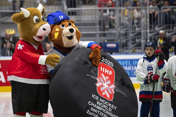 epa07604367 Macejko (C), official mascot of the IIHF Ice Hockey World Championship 2019, stands next to 2020 mascot Cooly (L) during the IIHF World Championship ice hockey final between Canada and Fin ...