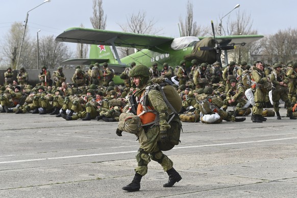 A Russian paratrooper walks as other wait to be load into a plane for airborne drills during maneuvers in Taganrog, Russia, Thursday, April 22, 2021. Russia&#039;s defense minister on Thursday ordered ...