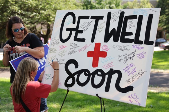 epa11478942 People sign get well messages for Republican presidential candidate former US President Donald Trump ahead of the Republican National Convention at Zeidler Park in Milwaukee, Wisconsin USA ...