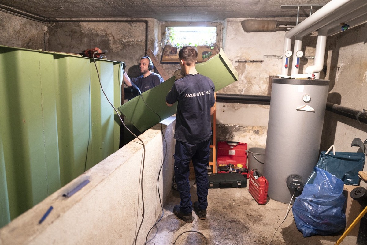 Zwei Heizungsinstallateure demontierten einen Oeltank im Keller eines Hauses, fotografiert am 4. Oktober 2021 in Zuerich. Die Oelheizung wird durch eine Erdwaermepumpe mit Erdsonde ersetzt. (KEYSTONE/ ...