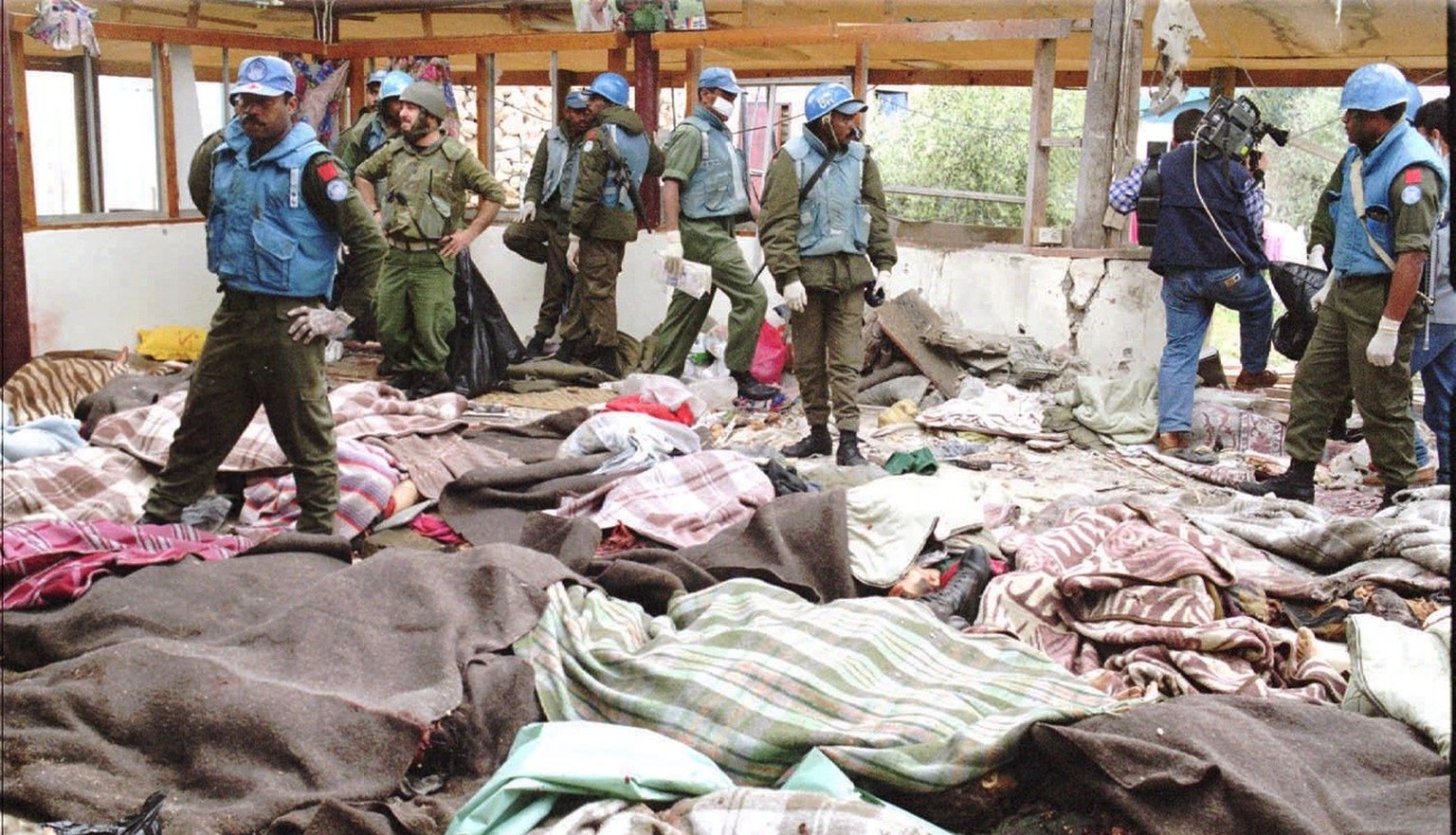 The bodies of Muslim refugees are covered by blankets at the headquaters of the Fijian battalion attached to the United Nations Peacekeeping forces, in the village of Qana Thursday, April 18 1996, aft ...