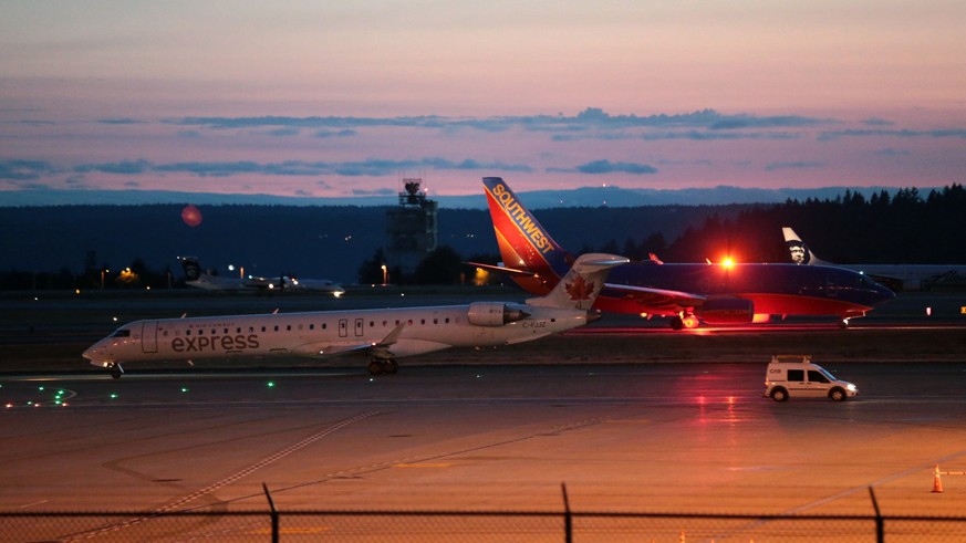 Planes sit on the tarmac at Sea-Tac International Airport after service was halted after an Alaska Airlines plane was stolen Friday, Aug. 10, 2018, in Wash. An airline mechanic stole an Alaska Airline ...