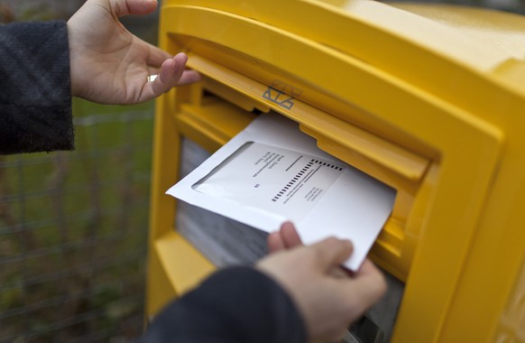 A woman drops an envelope with her vote-by-mail ballot in a letterbox on the occasion of the second tour of the election for the canton of Zurich&#039;s seat in the federal Council of States, pictured ...