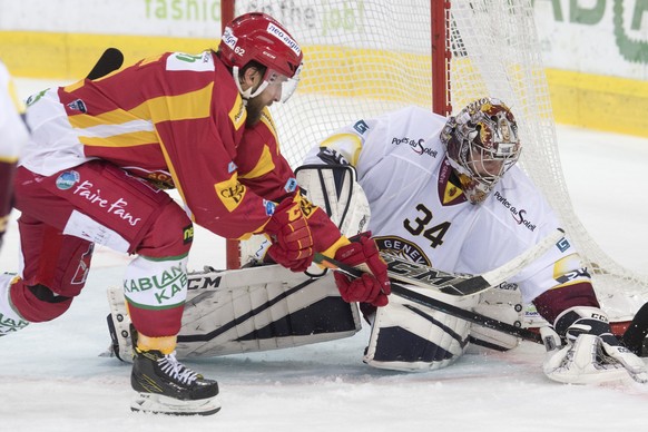 Tigers Alexei Dostoinov, links, kaempft um den Puck, gegen Servettes Goalie Gauthier Descloux, rechts, waehrend dem Meisterschaftsspiel der National League, zwischen den SCL Tigers und dem HC Genf - S ...