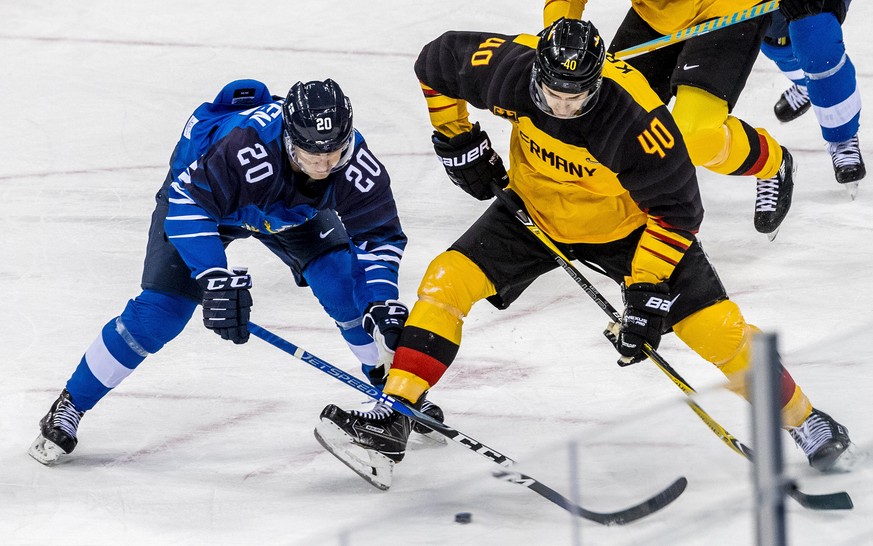 epa06526703 Bjorn Krupp (R) of Germany in action against Eeli Tolvanen (L) of Finland during the mens preliminary round match between Finland and Germany at the Gangneung Hockey Centre at the PyeongCh ...