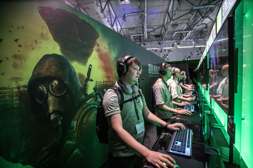 epa10815534 Visitors play Stalker 2 in front of monitors at the Microsoft Xbox boat during the Gamescom gaming convention in Cologne, Germany, August 23, 2023. The Gamescom gaming convention, the big…