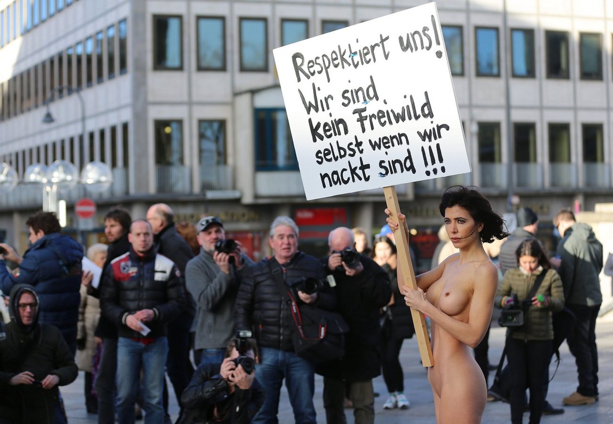 epa05092440 Swiss performance artist Milo Moire (R) holds a placard in her hand which reads 'Respect us! We are not unprotected game even when we are naked!' as she stands naked on the squar ...