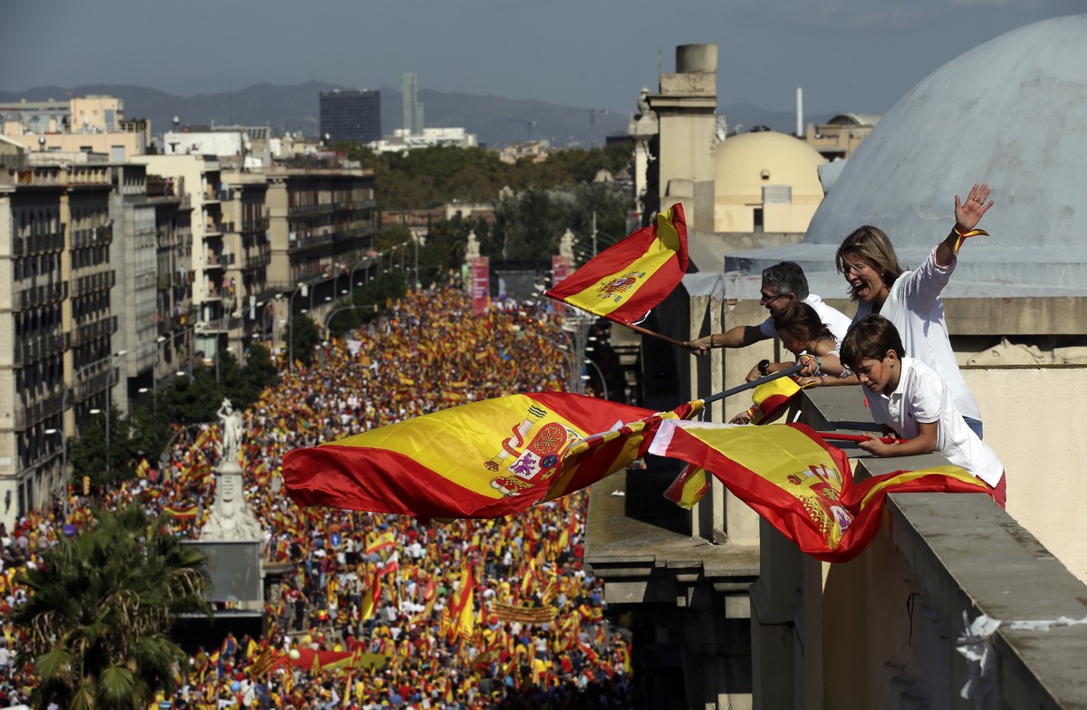 People on a rooftop wave Spanish flags during a march in downtown Barcelona, Spain, to protest the Catalan government's push for secession from the rest of Spain, Sunday Oct. 8, 2017. Sunday' ...