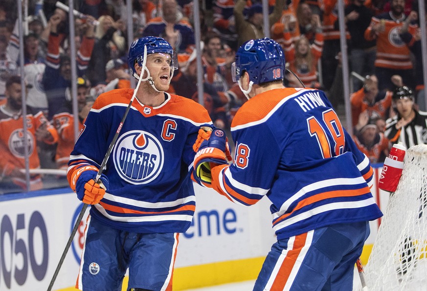 Edmonton Oilers' Connor McDavid (97) and Zach Hyman (18) celebrate a goal against the Vancouver Canucks during the second period of an NHL hockey game Wednesday, Oct. 12, 2022, in Edmonton, Alberta. ( ...