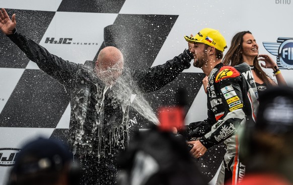 epa05504541 First placed German Moto2 driver Jonas Folger from Dynavolt Intact GP Team (R) and Dynavolt Intact GP Team manager Juergen Lingg (L) celebrate on the podium after the Moto2 race of the Mot ...