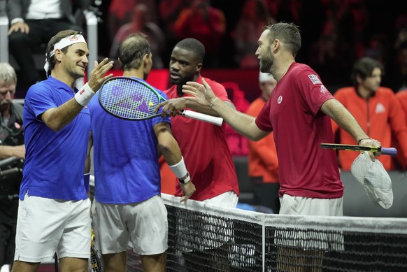 Team Europe&#039;s Roger Federer, left, and Rafael Nadal greet Team World&#039;s Jack Sock, right, and Frances Tiafoe after losing to them in a Laver Cup doubles match at the O2 arena in London, Frida ...