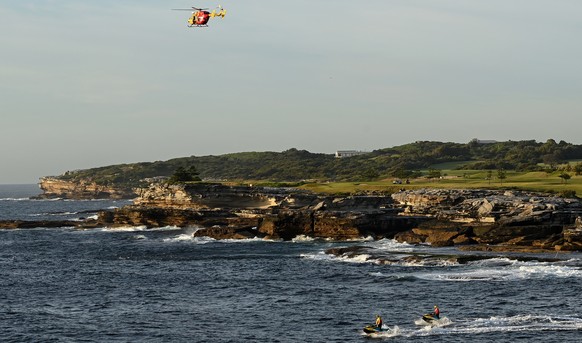 epa09764624 The NSW Life Saver Rescue helicopter and NSW Life Savers on jet skis search the water at Buchan Point in Malabar, off Little Bay Beach in Sydney, Australia, 17 February 2022. Beaches in Sy ...