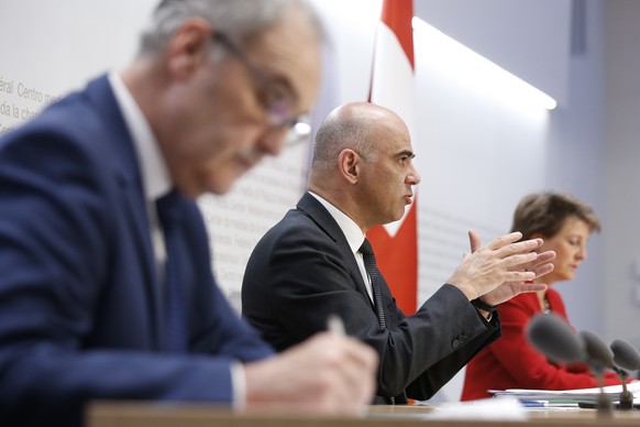 Bundesrat Alain Berset, Mitte, spricht an der Seite von Bundespraesidentin Simonetta Sommaruga, hinten, und Bundesrat Guy Parmelin, waehrend einer Medienkonferenz des Bundesrates ueber die Situation d ...