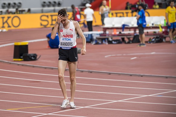 Julien Wanders from Switzerland reacts as he stops the race during the 10&#039;000 meters men&#039;s final at the IAAF World Athletics Championships, at the Khalifa International Stadium, in Doha, Qat ...