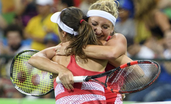 epa05460607 Timea Bacsinszky, right, and Martina Hingis, left, of Switzerland celebrate the victory after the womenÕs first round doubles match against Daria Gavrilova and Samantha Stosur from Austral ...