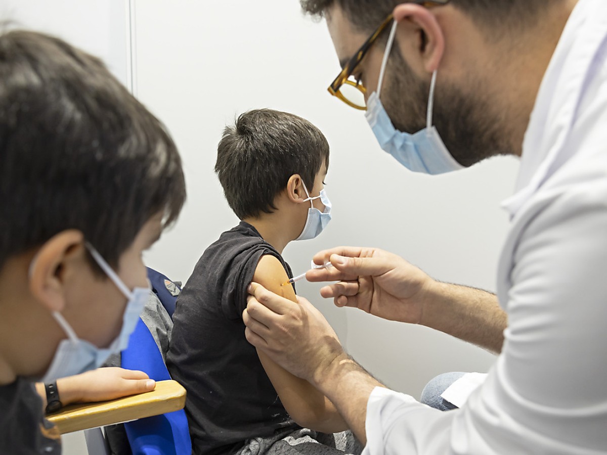 A Genève, le jeune Abel, 8 ans, reçoit son vaccin contre le Covid-19 sous les yeux de son frère jumeau Santiago.
