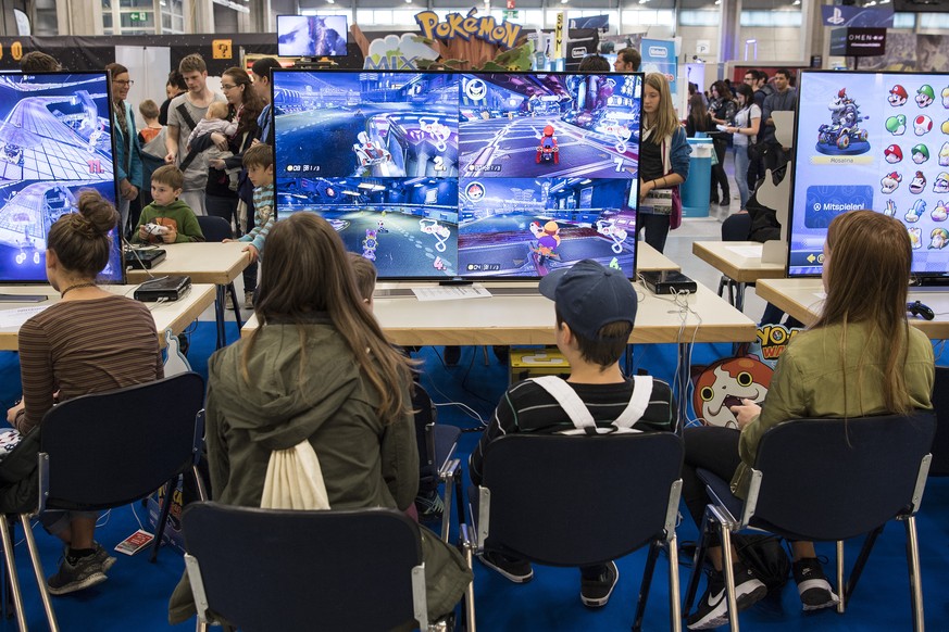 Personen erfreuen sich an elektronischen Spielen auf einem Split Screen wie Mario Kart an der Spielzeugmesse Suisse Toy, am Donnerstag, 6. Oktober 2016, in Bern. Die Suisse Toy ist der groesste Schwei ...