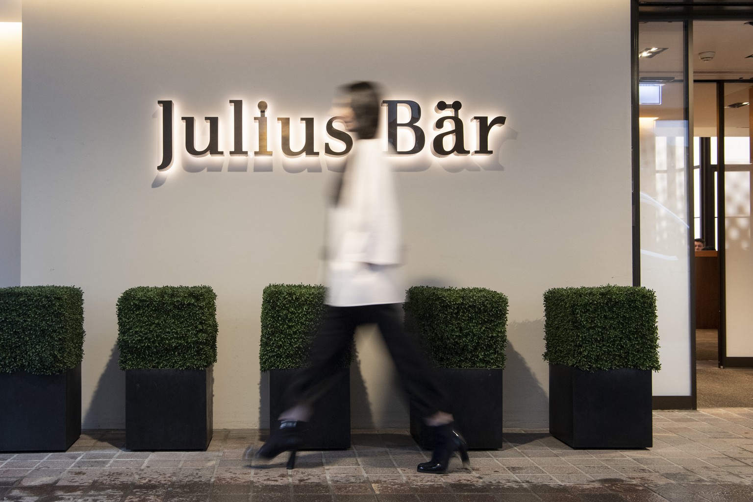 ARCHIV --- ZUR MELDUNG VON SCHWEREN MAENGELN BEI DER GELDWAESCHEREIBEKAEMPFUNG BEI DER BANK JULIUS BAER STELLEN WIR IHNEN FOLGENDES BILDMATERIAL ZUR VERFUEGUNG --- Eine Frau laeuft vor dem Logo der Ju ...