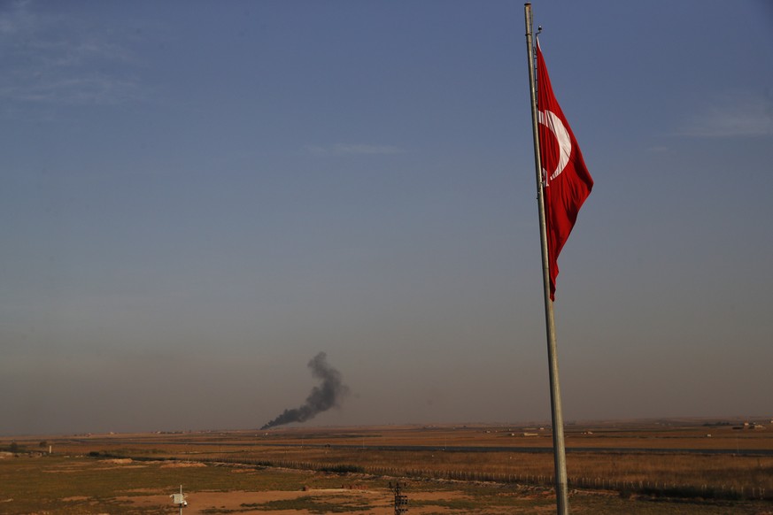 In this photo taken from the Turkish side of the border between Turkey and Syria, in Akcakale, Sanliurfa province, southeastern Turkey, smoke billows from a fire inside Syria during bombardment by Tur ...