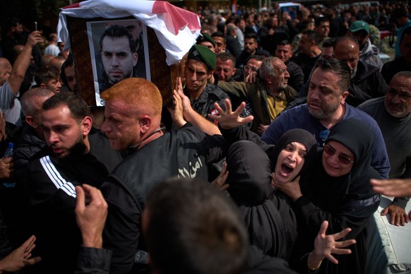 Mourners react during the funeral of 13 state security officers killed the previous day in an Israeli strike in Lebanon's coastal city of Sidon, Saturday, April 11, 2026. (AP Photo/Emilio Morenat ...