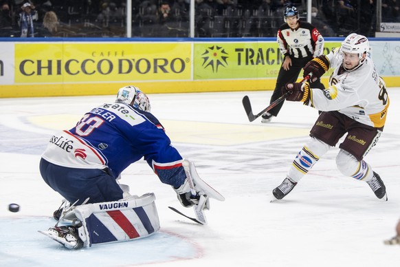 Servettes Joel Vermin, rechts, trifft im Penalty gegen Zuerichs Torhueter Lukas Flueeler im Eishockeyspiel der National League zwischen den ZSC Lions und dem Geneve-Servette HC am Freitag, 9. Oktober  ...