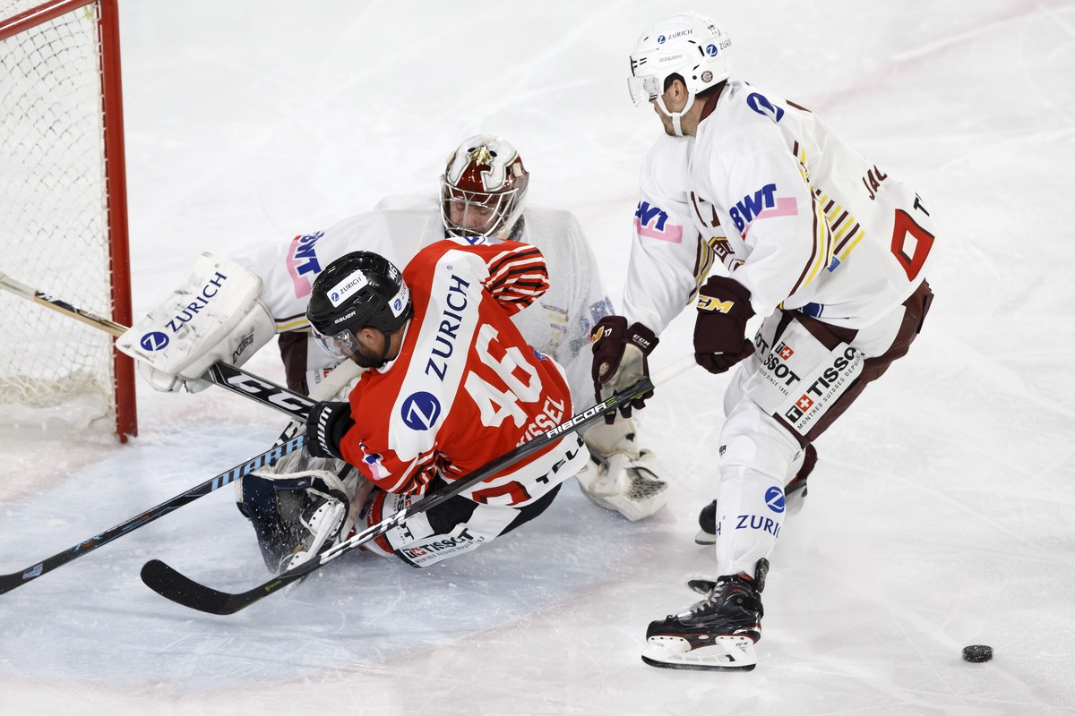 Visp's forward Dan Kissel, centre, vies for the puck with Geneve-Servette's goaltender Gauthier Descloux, left, and Geneve-Servette's defender Arnaud Jacquemet, right, during the Swiss  ...