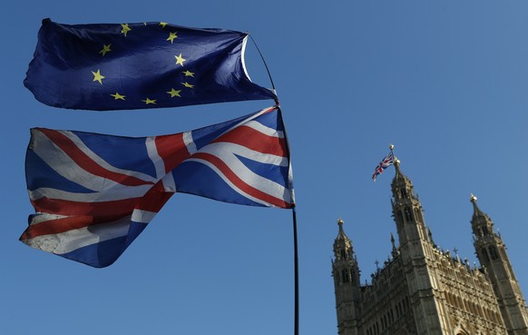 FILE - In this Wednesday, Feb. 27, 2019 file photo the flag of the European Union and the British national flag are flown on poles during a demonstration by remain in the EU outside spporters the Pala ...