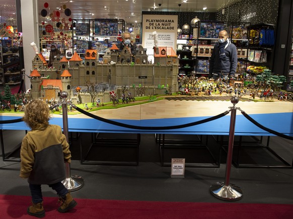 A little boy looks at a model of the Escalade build with 13,000 pieces of Playmobil, realized by a father and his two children displaying at the departement store Manor, in Geneva, Switzerland, Friday ...