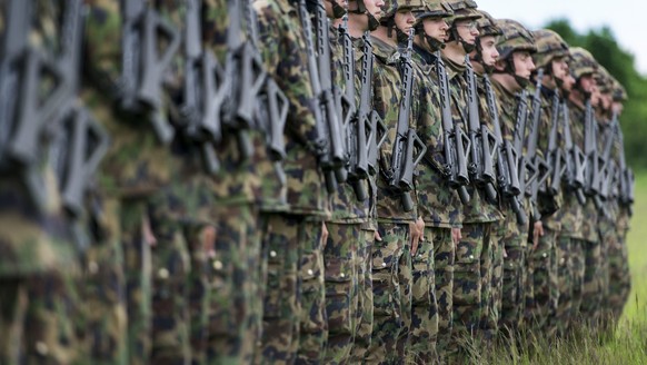 Infantry recruits stand in a row on a green field, pictured on May 17, 2013, in the infantry recruit school of the Swiss army in Colombier, canton of Neuchatel, Switzerland. (KEYSTONE/Christian Beutle ...
