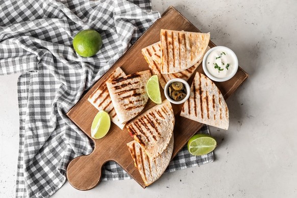 Quesadillas mit Limettenstücke und Sauerrahm.