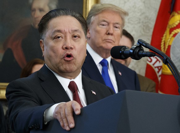 FILE - In this Thursday, Nov. 2, 2017, file photo, Broadcom CEO Hock Tan speaks while U.S. President Donald Trump listens, in background, during an event at the White House in Washington, to announce  ...