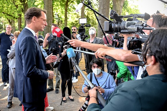 epa09948193 Hendrik Wuest (L), Prime Minister of North Rhine-Westphalia state and Christian Democrats (CDU) top candidate for the state elections, speals to media after casting the ballot for the elec ...