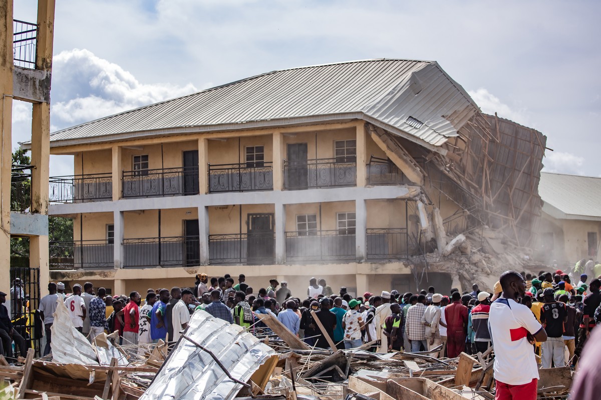 epa11474926 People gather at the site of a collapsed building at Saint Academy school in Jos North, district of Plateau State, Nigeria, 12 July 2024. Nigeria?s National Emergency Management Agency (NE ...